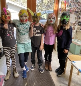 Marlene Alexander with students wearing masks they've created