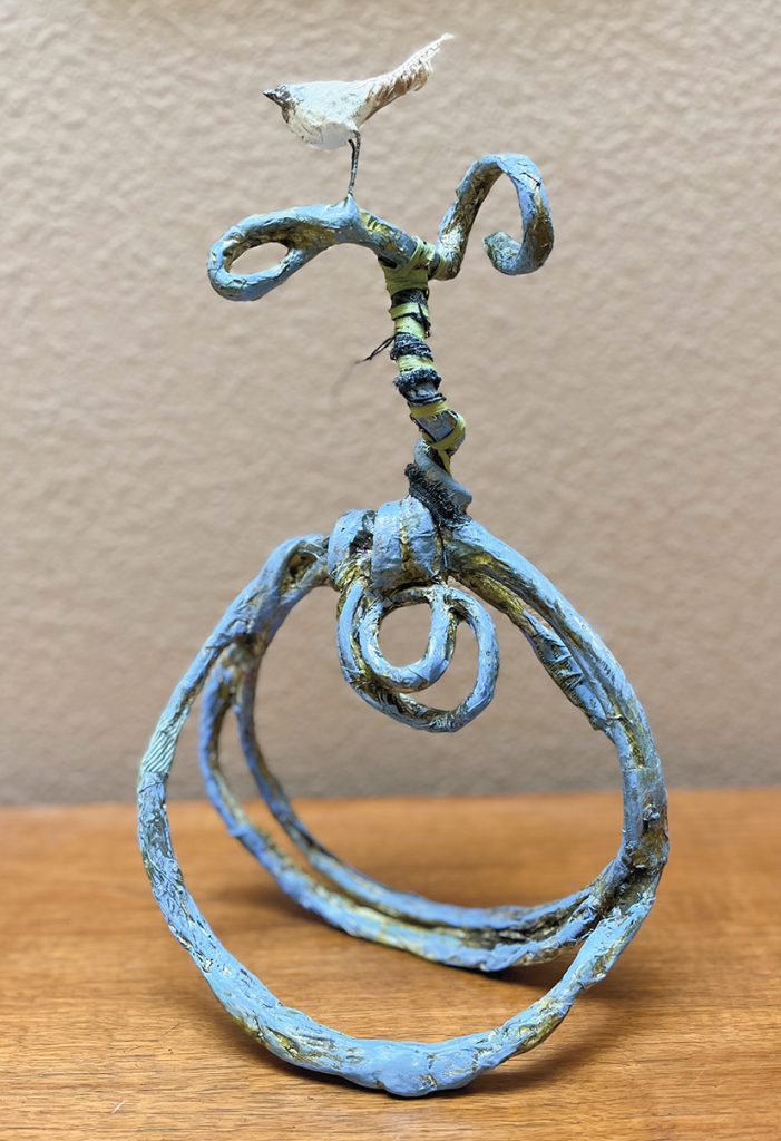 Loopdeeloop is a curly cue sculpture with a bird on top with robins egg blue patina